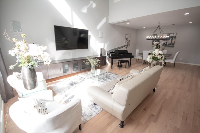 living area with a notable chandelier, recessed lighting, wood finished floors, and baseboards