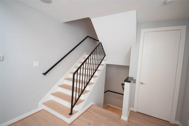 stairs with baseboards and wood finished floors