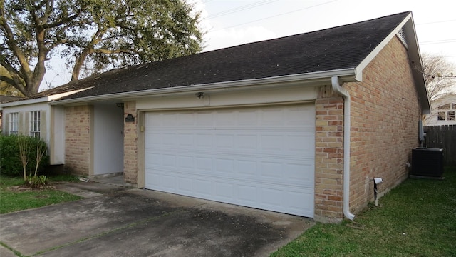 garage featuring central AC unit and concrete driveway