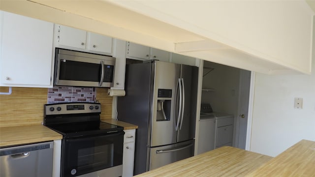 kitchen with appliances with stainless steel finishes, independent washer and dryer, and backsplash