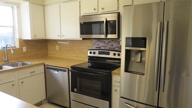 kitchen with light countertops, appliances with stainless steel finishes, backsplash, and a sink