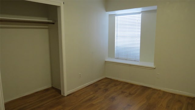 unfurnished bedroom featuring a closet, baseboards, and wood finished floors