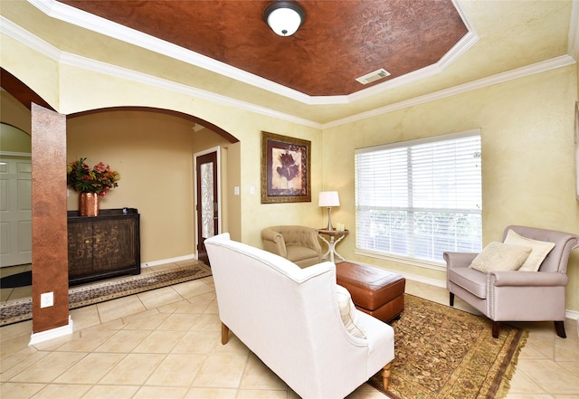 interior space featuring visible vents, baseboards, a tray ceiling, light tile patterned flooring, and arched walkways