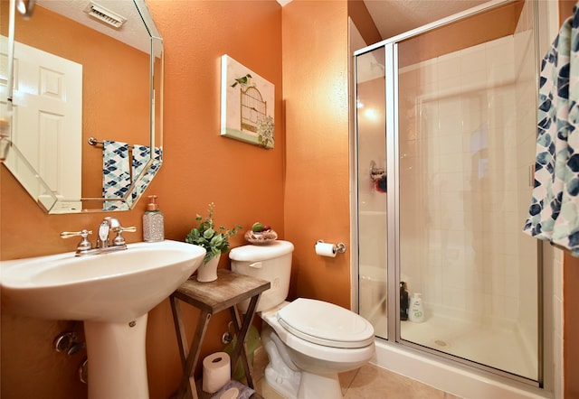 bathroom featuring tile patterned flooring, a shower stall, toilet, and visible vents