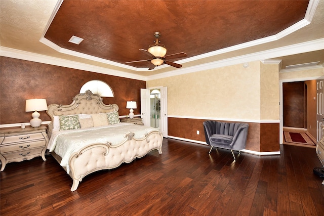 bedroom with hardwood / wood-style floors, a raised ceiling, crown molding, and a ceiling fan