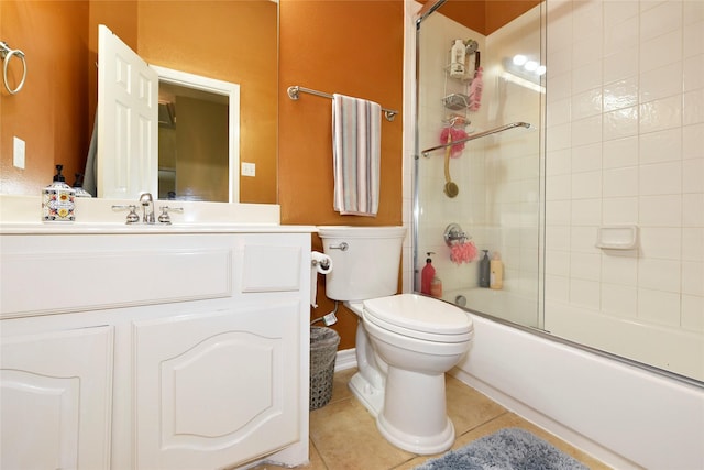 full bathroom featuring vanity, toilet, bath / shower combo with glass door, and tile patterned flooring