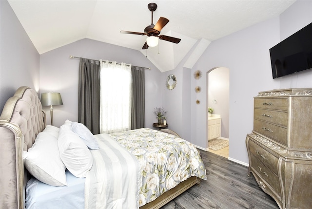 bedroom with a ceiling fan, baseboards, lofted ceiling, dark wood-style flooring, and connected bathroom