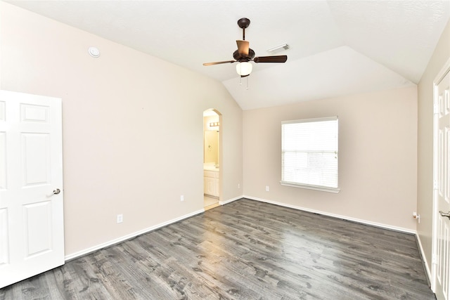 spare room with vaulted ceiling, wood finished floors, arched walkways, and visible vents