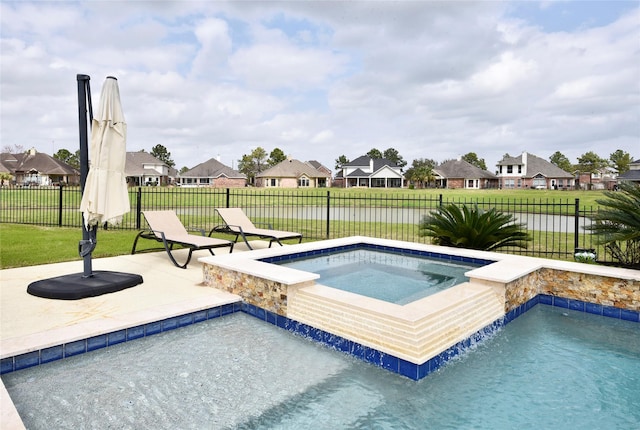 view of swimming pool featuring an in ground hot tub, a fenced backyard, a lawn, a patio area, and a residential view