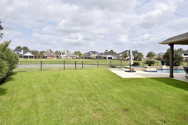 view of yard with a residential view, a patio, a fenced backyard, and a pool with connected hot tub