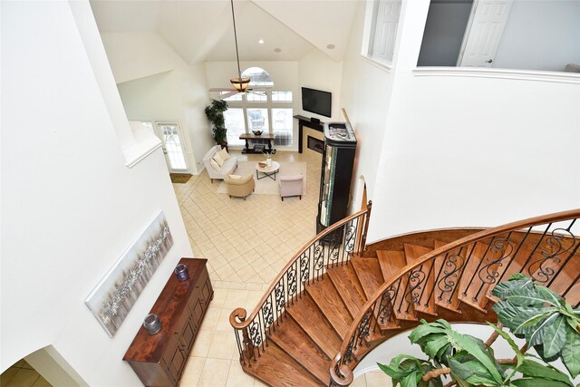 23518 Windy Bank Ln, Richmond, TX 77407 - living area featuring a high ceiling, ceiling fan, light tile patterned floors, and stairway