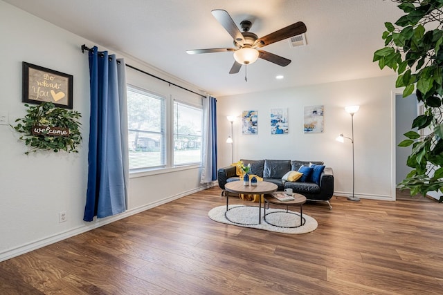 living room featuring baseboards, ceiling fan, visible vents, and wood finished floors