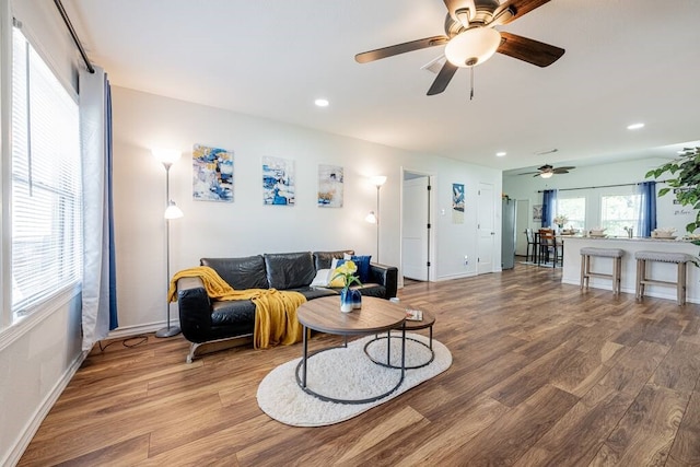 living area featuring baseboards, wood finished floors, and recessed lighting