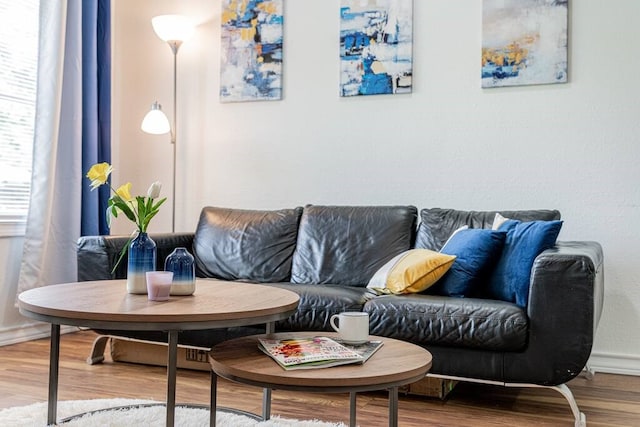 living room with breakfast area, wood finished floors, and baseboards