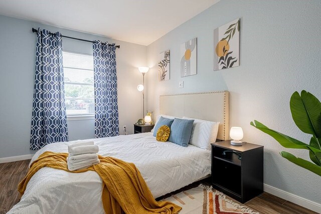 bedroom with wood finished floors and baseboards