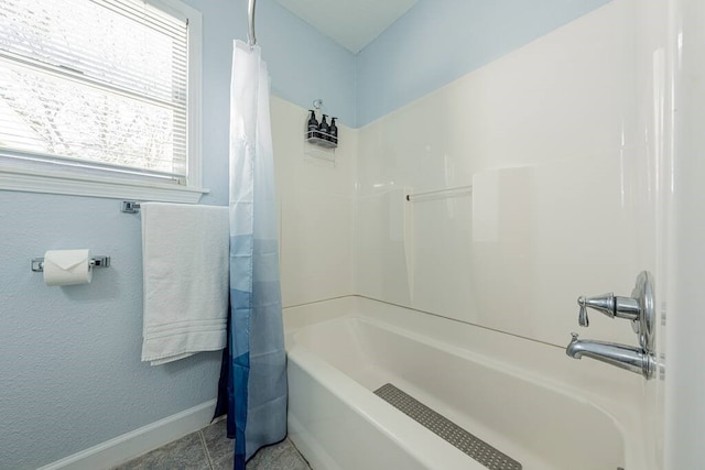 bathroom with shower / tub combo with curtain, baseboards, and tile patterned floors