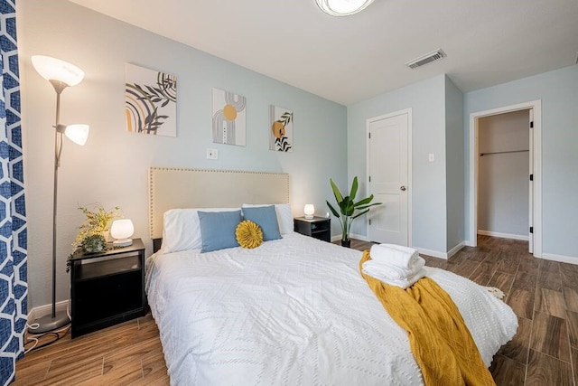 bedroom with visible vents, baseboards, and wood finished floors