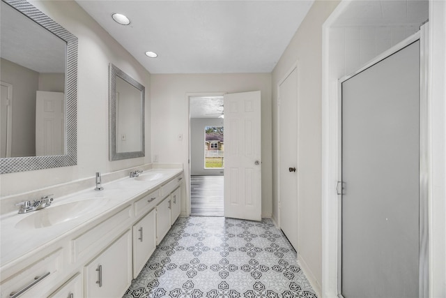 bathroom with double vanity, recessed lighting, a sink, and a shower with shower door