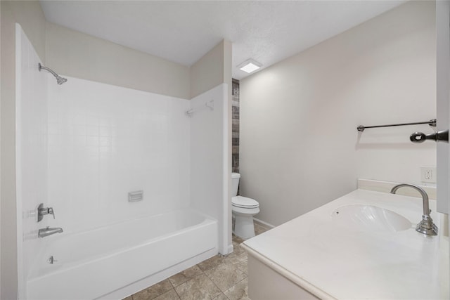 bathroom with washtub / shower combination, vanity, and toilet