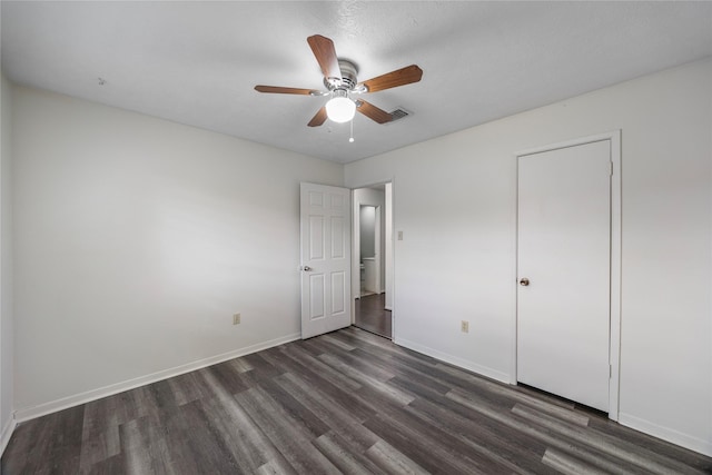 unfurnished bedroom with a ceiling fan, dark wood-style flooring, and baseboards