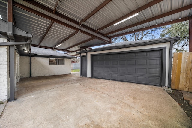 garage with a carport and fence