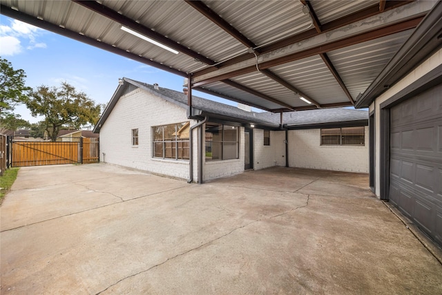 view of patio / terrace featuring a garage, a gate, and fence