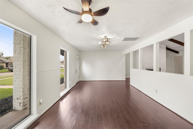 unfurnished room with a ceiling fan, visible vents, a textured ceiling, and wood finished floors