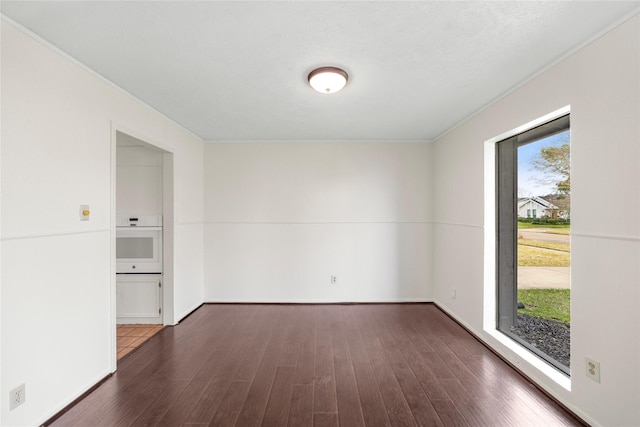 unfurnished room with baseboards and wood finished floors