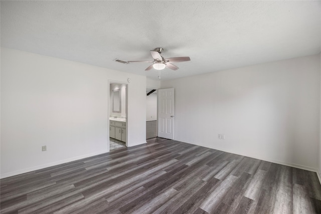 unfurnished bedroom with visible vents, dark wood finished floors, a textured ceiling, and ensuite bathroom