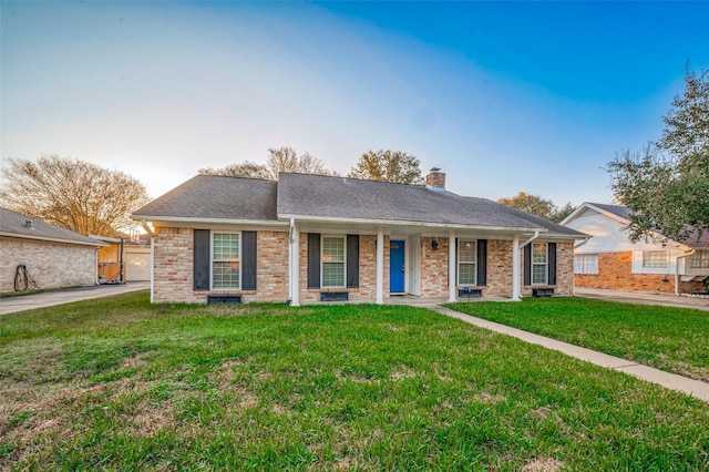 single story home with a shingled roof, a chimney, a front lawn, and brick siding