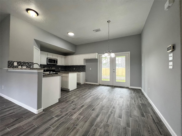 kitchen featuring dark wood-style floors, visible vents, backsplash, appliances with stainless steel finishes, and white cabinets