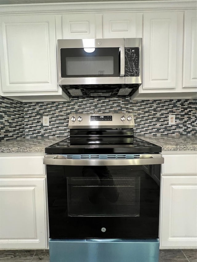 kitchen featuring white cabinetry, appliances with stainless steel finishes, light countertops, and backsplash