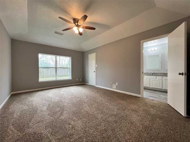 unfurnished bedroom with lofted ceiling, baseboards, visible vents, and light colored carpet