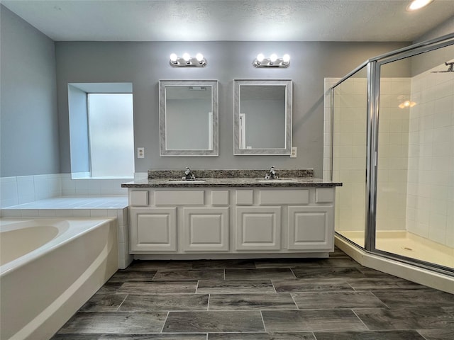 full bathroom with a bath, a shower stall, wood tiled floor, and a sink