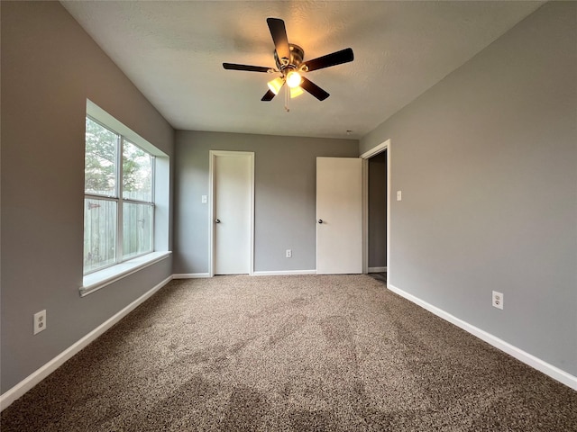 unfurnished bedroom featuring a textured ceiling, carpet floors, ceiling fan, and baseboards