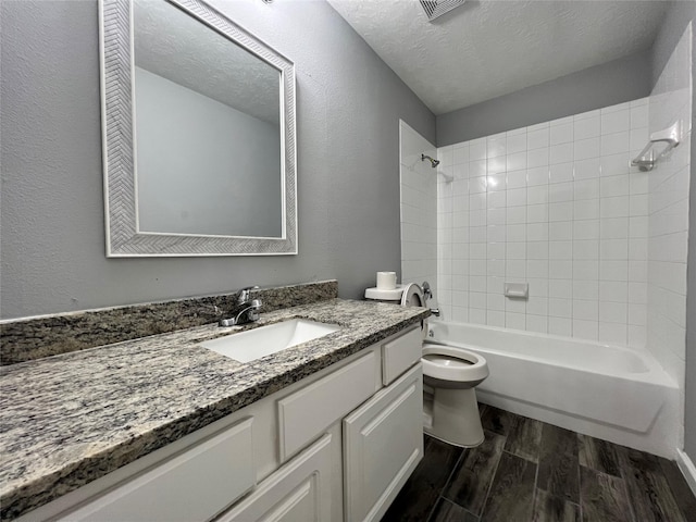 bathroom with toilet, a textured ceiling, bathtub / shower combination, and wood finished floors