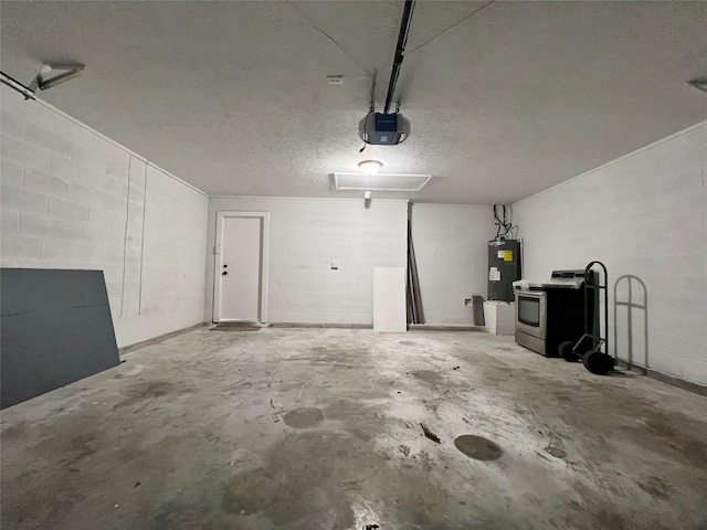 garage with water heater, concrete block wall, and a garage door opener