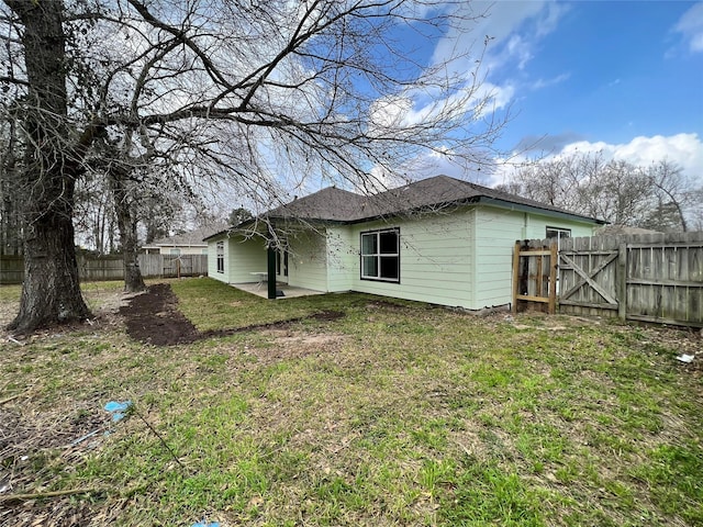 rear view of house featuring a yard, a patio area, and a fenced backyard