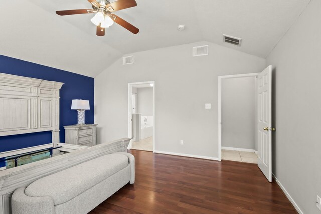 bedroom featuring visible vents, baseboards, wood finished floors, and vaulted ceiling