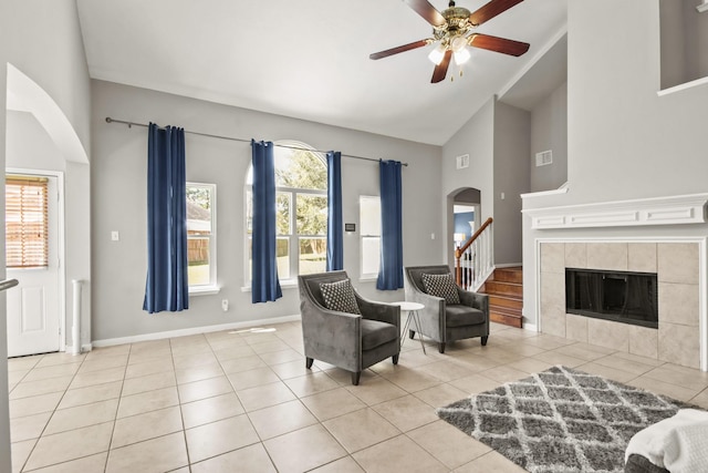 sitting room with arched walkways, plenty of natural light, a tile fireplace, and visible vents