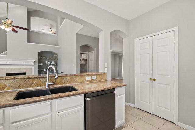 kitchen with dishwasher, light tile patterned floors, decorative backsplash, white cabinets, and a sink