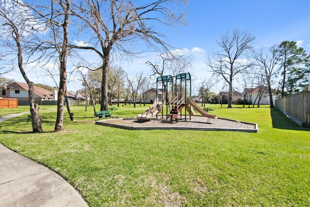 community jungle gym featuring a yard and fence