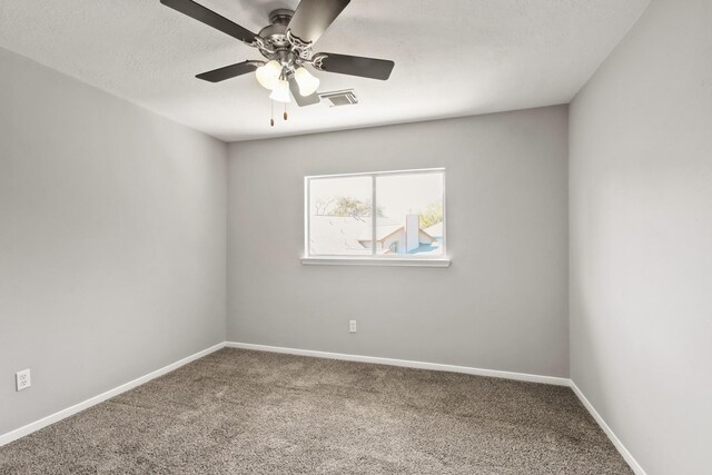 carpeted empty room featuring visible vents, ceiling fan, a textured ceiling, and baseboards