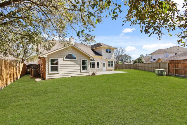 back of house with a lawn, a patio, a chimney, and a fenced backyard