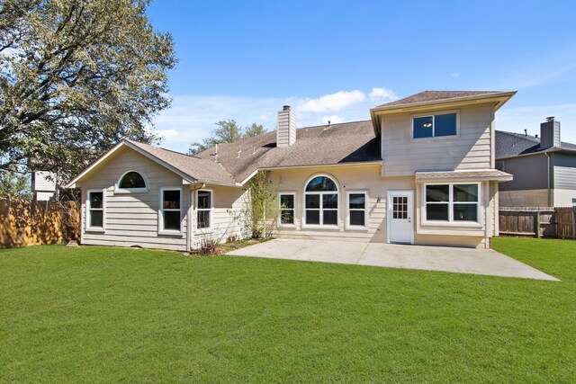 back of property featuring a patio, a yard, fence, and a chimney