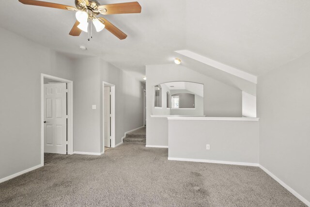 unfurnished living room with baseboards, carpet, and vaulted ceiling