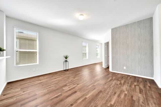 unfurnished room featuring wood finished floors and baseboards