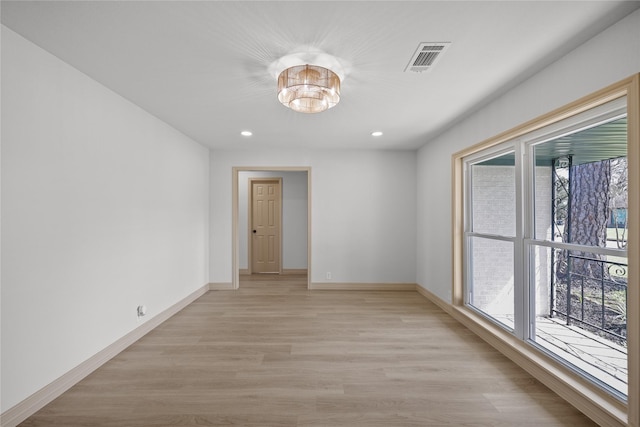 empty room with recessed lighting, light wood-style floors, visible vents, and baseboards