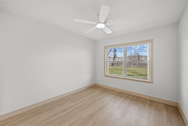 spare room with light wood-style flooring, a ceiling fan, and baseboards