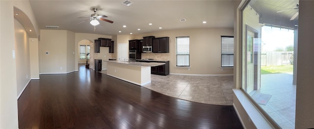 kitchen featuring visible vents, arched walkways, a ceiling fan, appliances with stainless steel finishes, and open floor plan